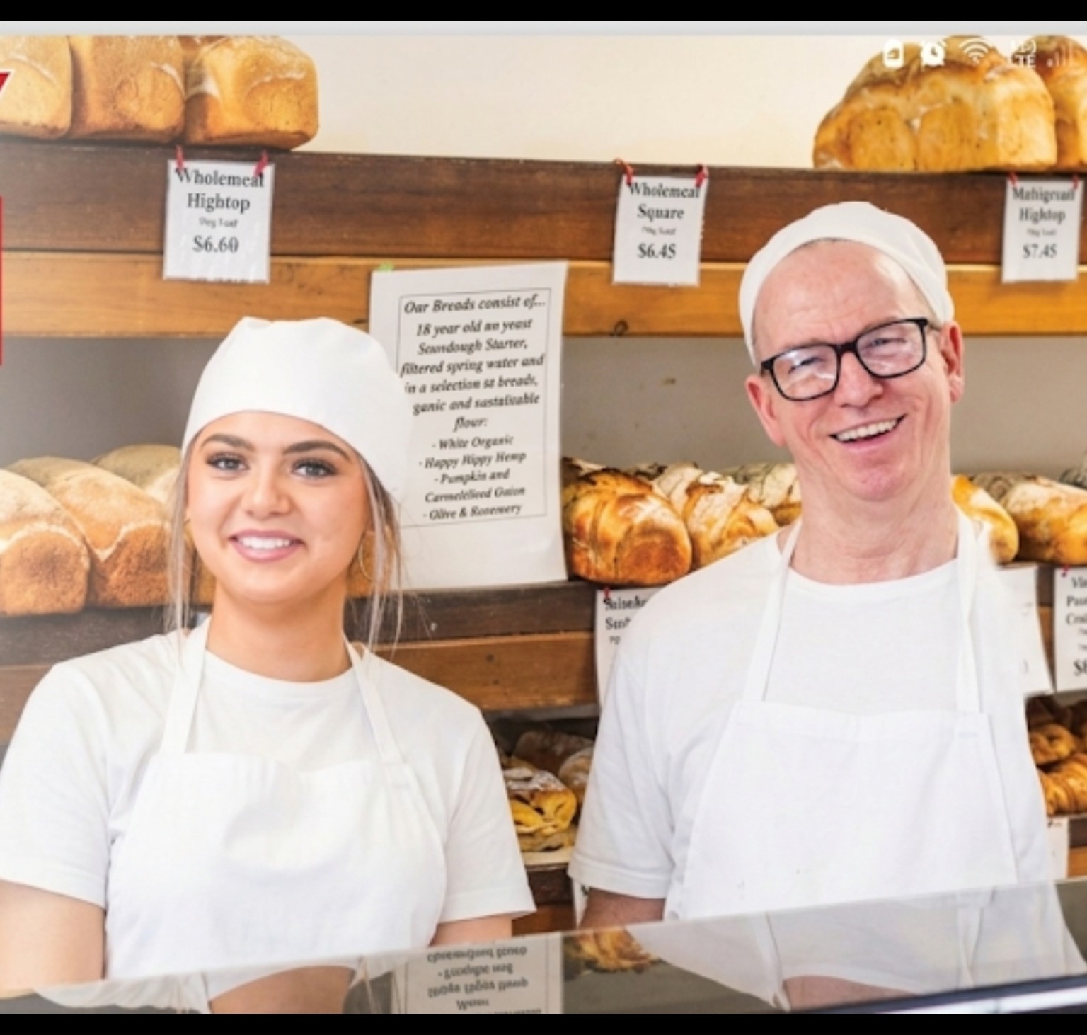 Philip and a fellow baker smiling behind the bakery counter