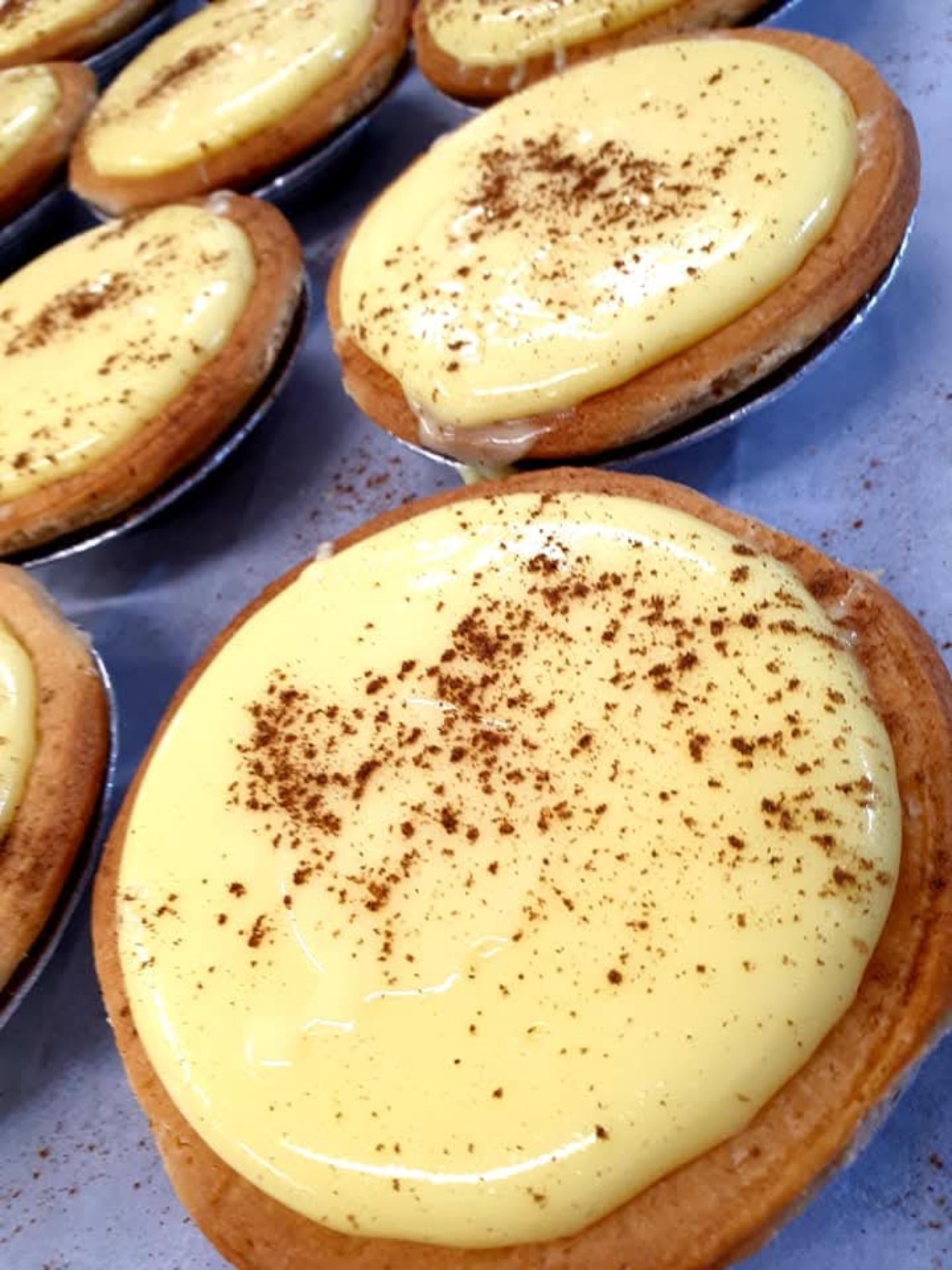 Golden custard tarts with a light dusting of spice